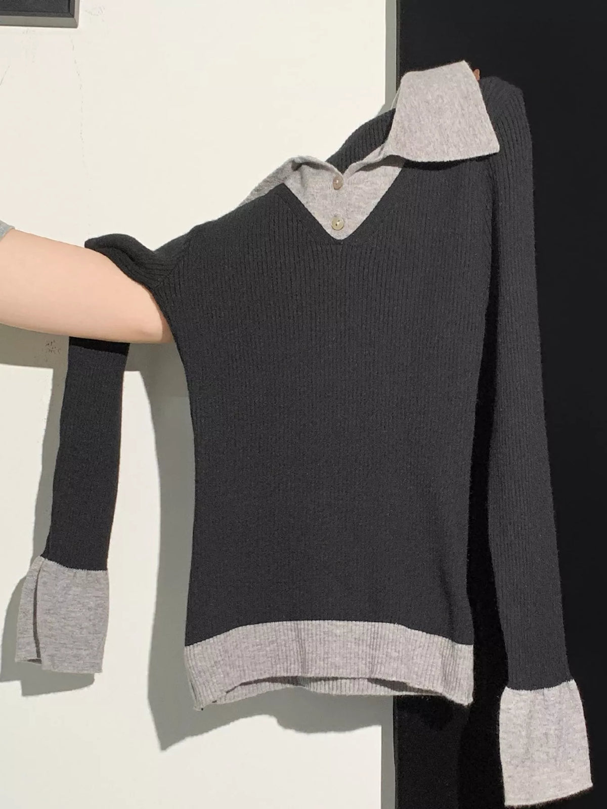 Black ribbed knit top with gray collar, button placket, cuffs, and hem