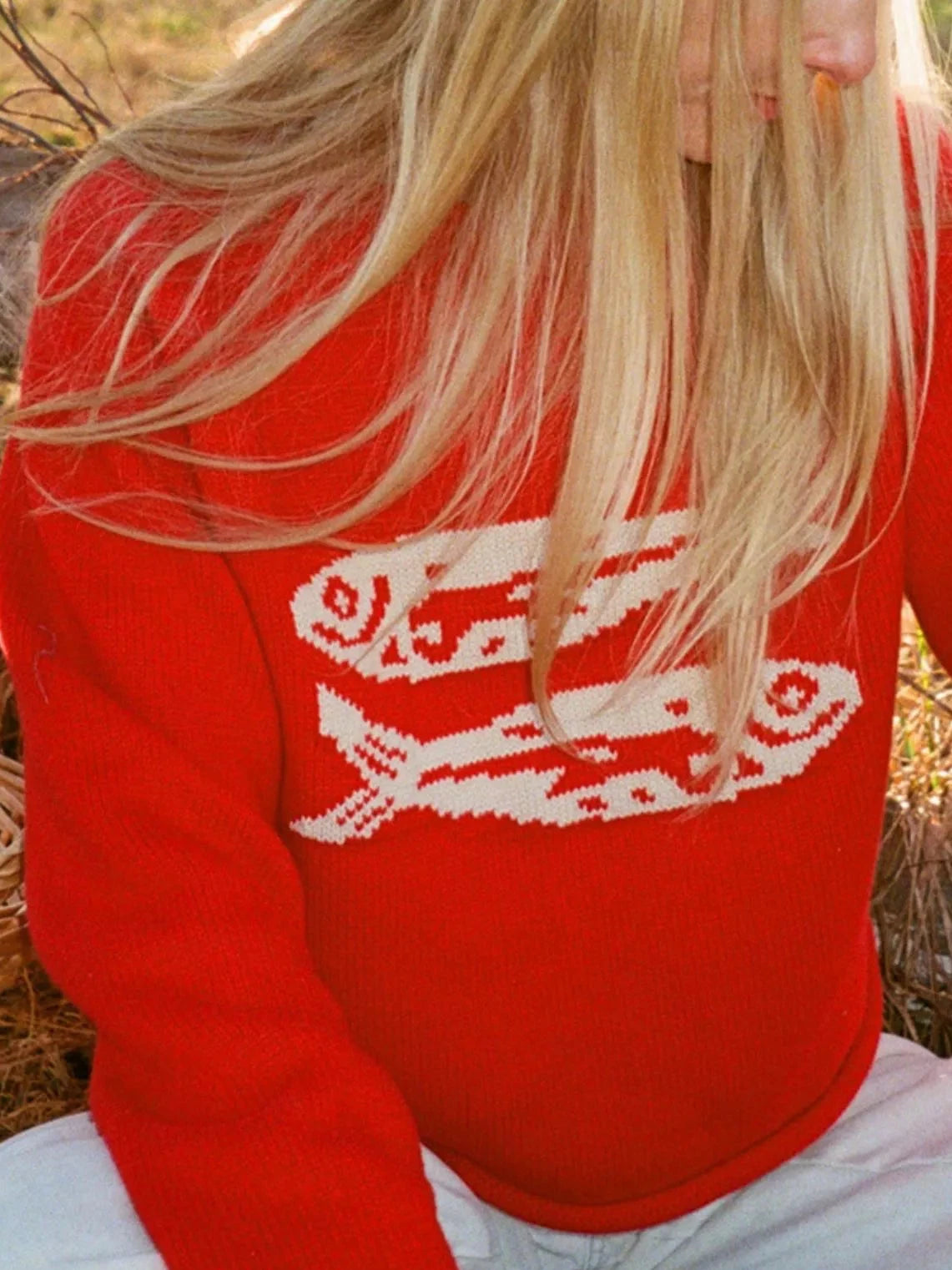 Red crew neck knit sweater with white fish motif and long sleeves