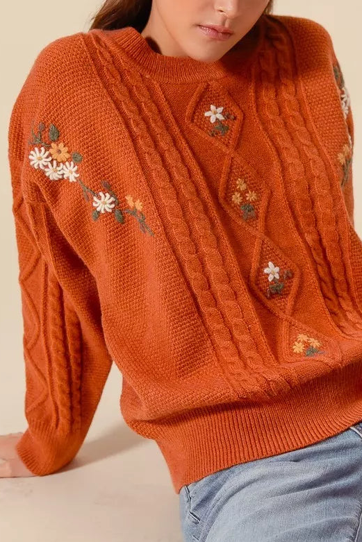 Brick crewneck cable knit sweater with small flower embroidery on sleeves and front