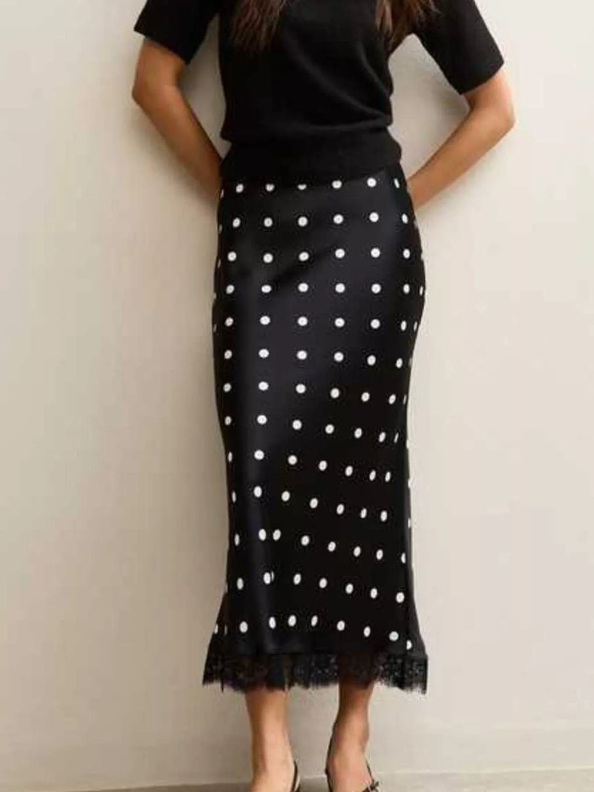 Black polka dot midi skirt with lace trim, shown from the front.