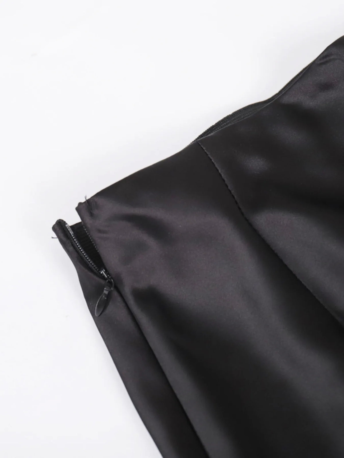 Close-up of black satin-like maxi skirt with visible side zipper pull